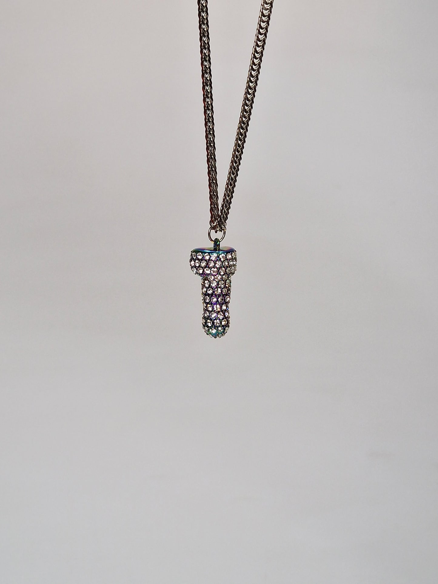 A unique necklace in multicolor metal covered with crystals and shaped like a penis or cock
