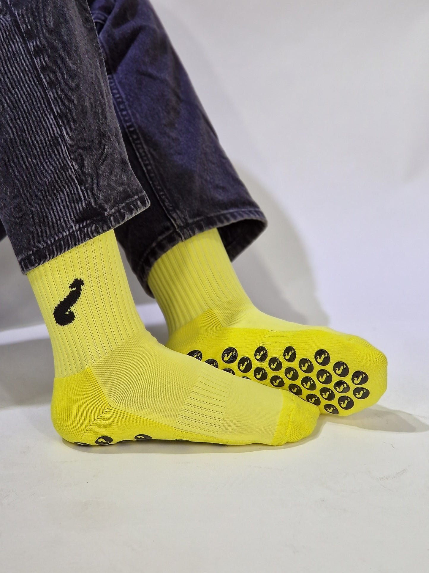 Mannschaftssocken. Gelb/schwarze Sportsocken mit Anti-Rutsch und aufgesticktem Schwanz