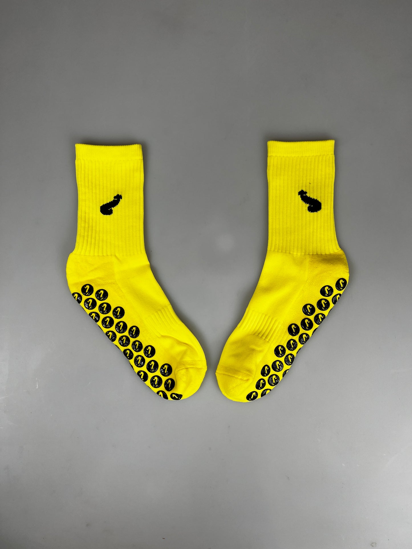 Mannschaftssocken. Gelb/schwarze Sportsocken mit Anti-Rutsch und aufgesticktem Schwanz