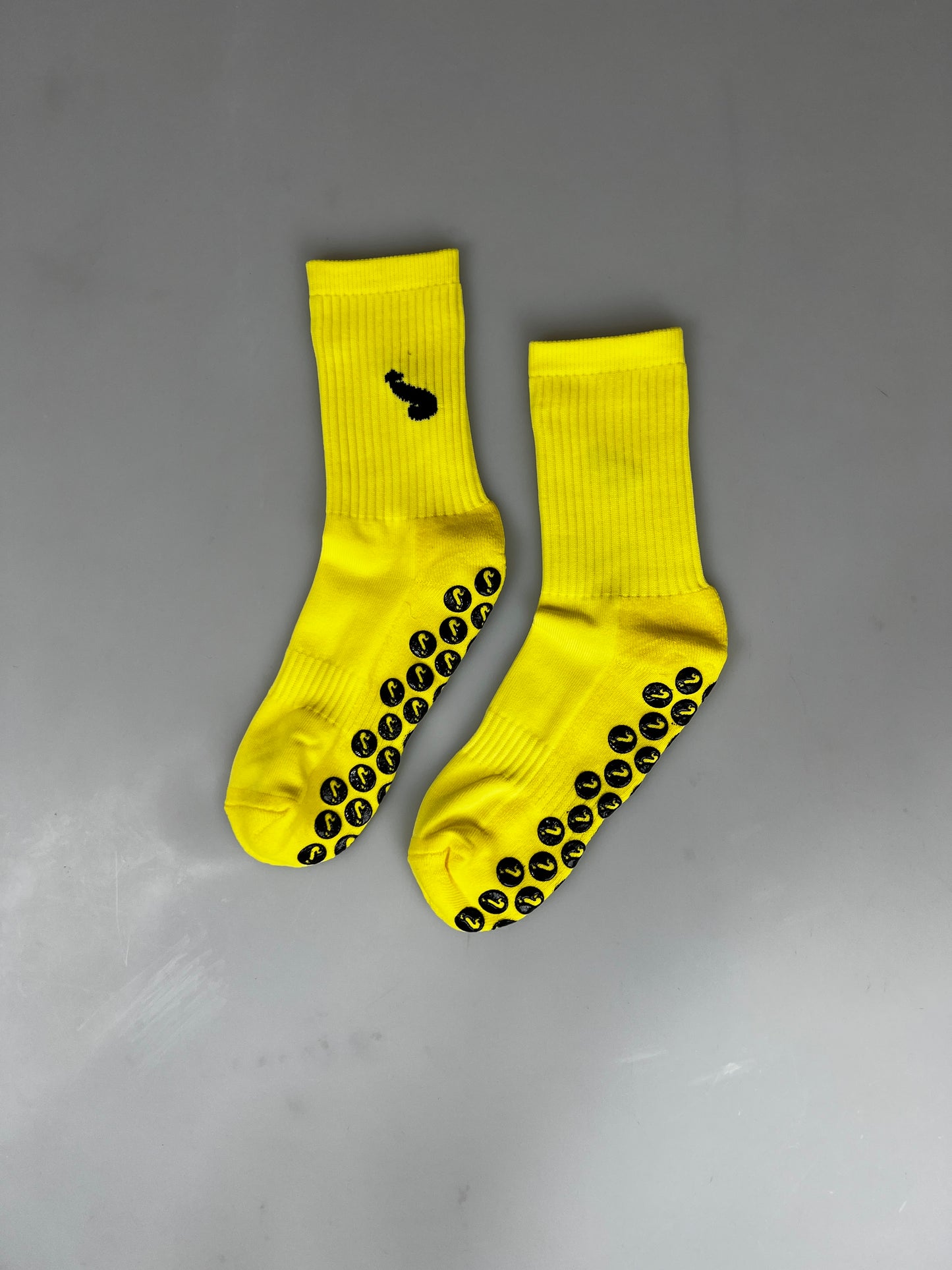 Mannschaftssocken. Gelb/schwarze Sportsocken mit Anti-Rutsch und aufgesticktem Schwanz