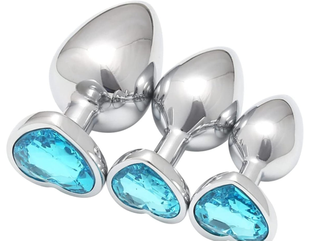 Buttplug i nickelfritt guld eller silverfärgat stål med kristallhjärtan i rosa, lila, blått och transparent färg
