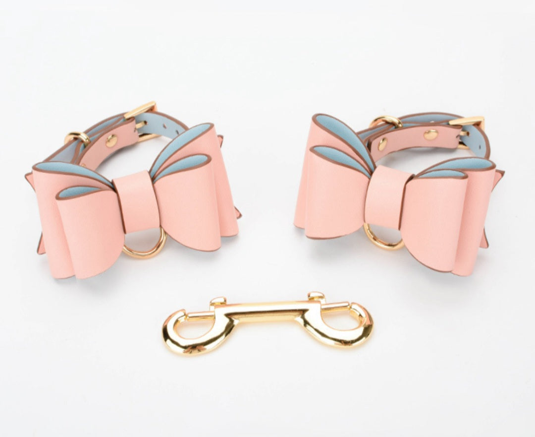 Puños de cuero rosa atrevidos y elegantes con lazo para manos o pies.