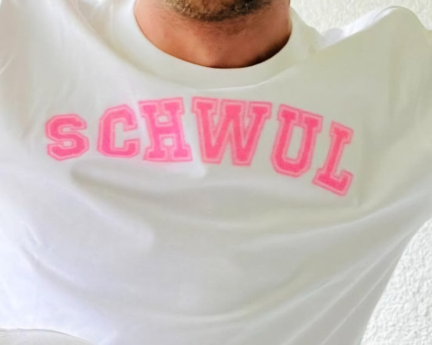 Camiseta con el estampado SCHWUL en purpurina rosa en el pecho