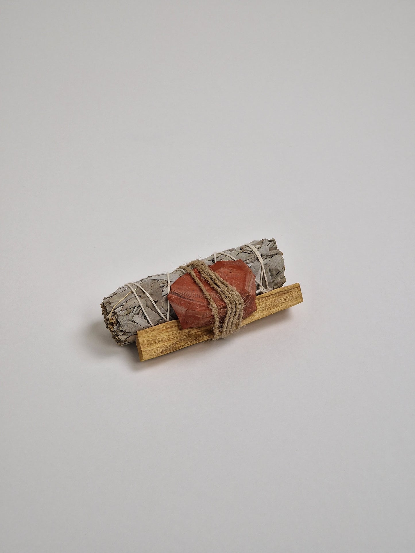 Roter Jaspis, roter Jaspiskristall mit weißem Salbei, Räucherstäbchen und Palo Santo