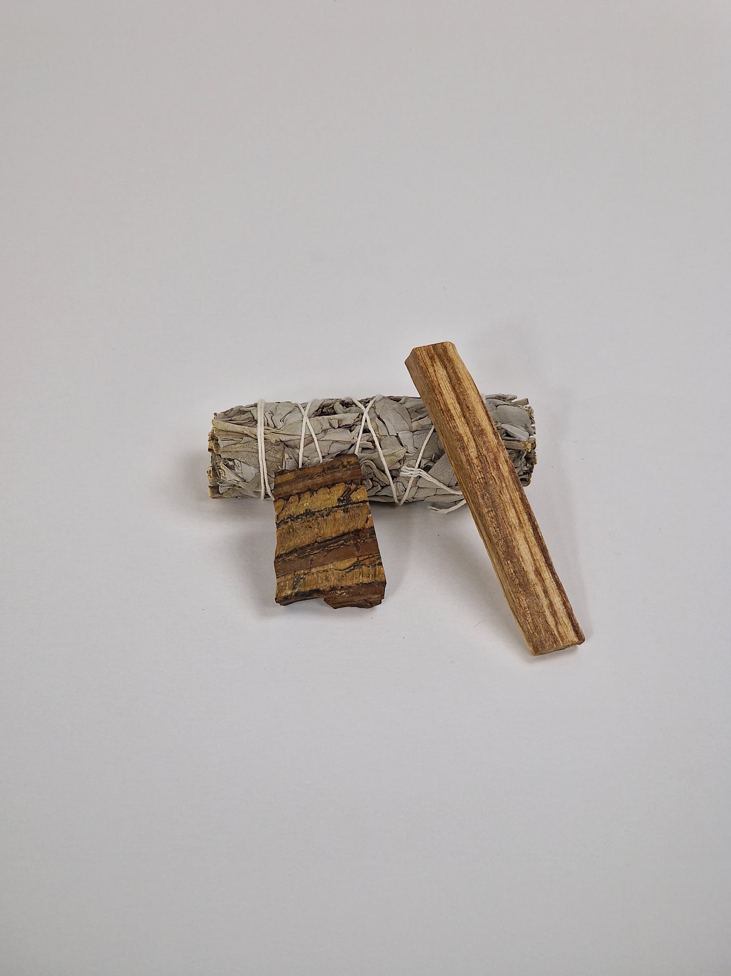 Tigerauge, Tigerauge mit weißem Salbei, Räucherstäbchen und einem Stück Palo Santo, heiligem Holz
