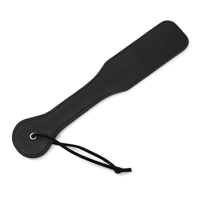 Paddle whip in leather, whipping tool, with the text "XOXO" cut out