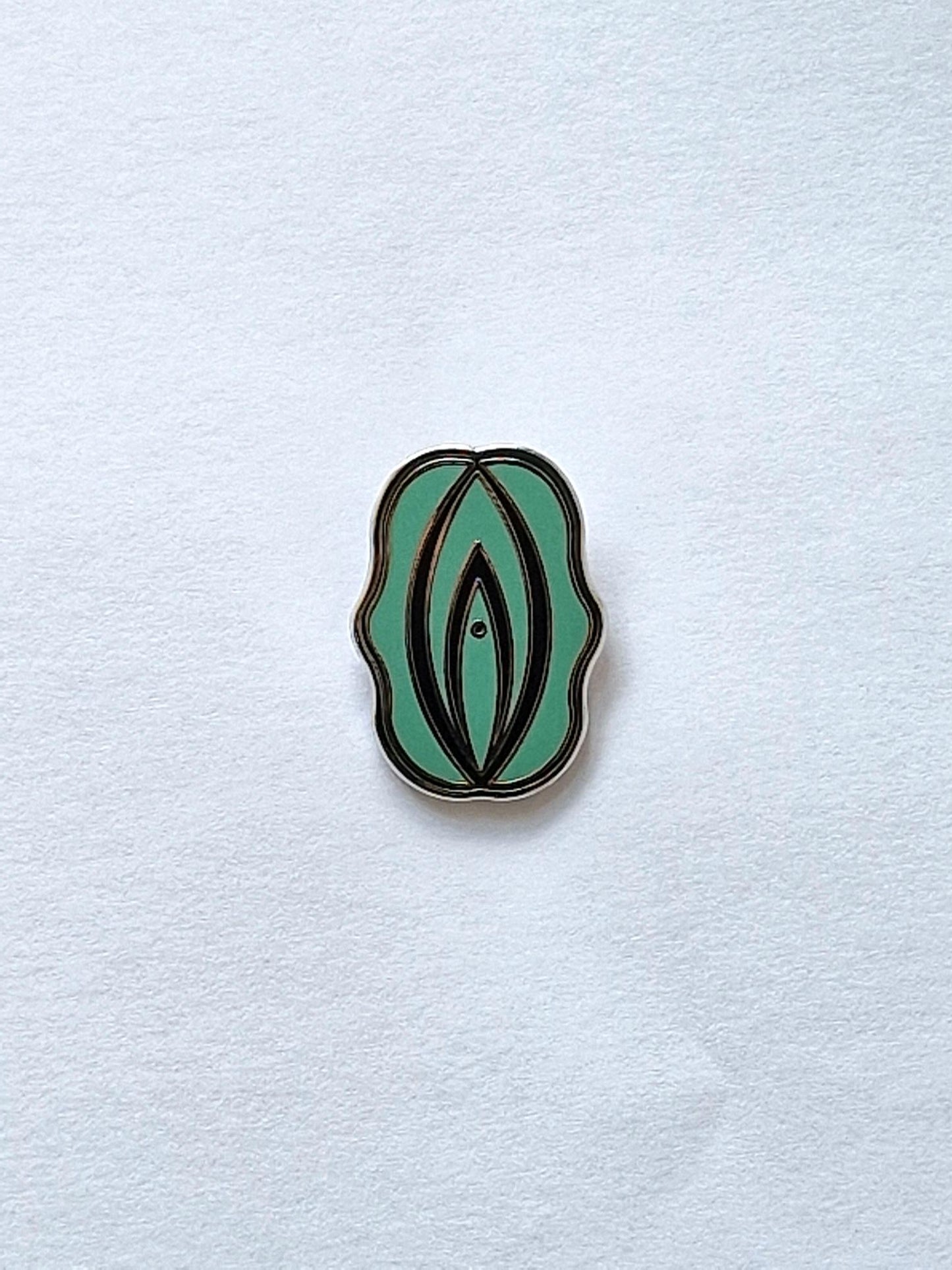 Rolig och personlig pins i form av en grön och svart fiffi eller snippa.