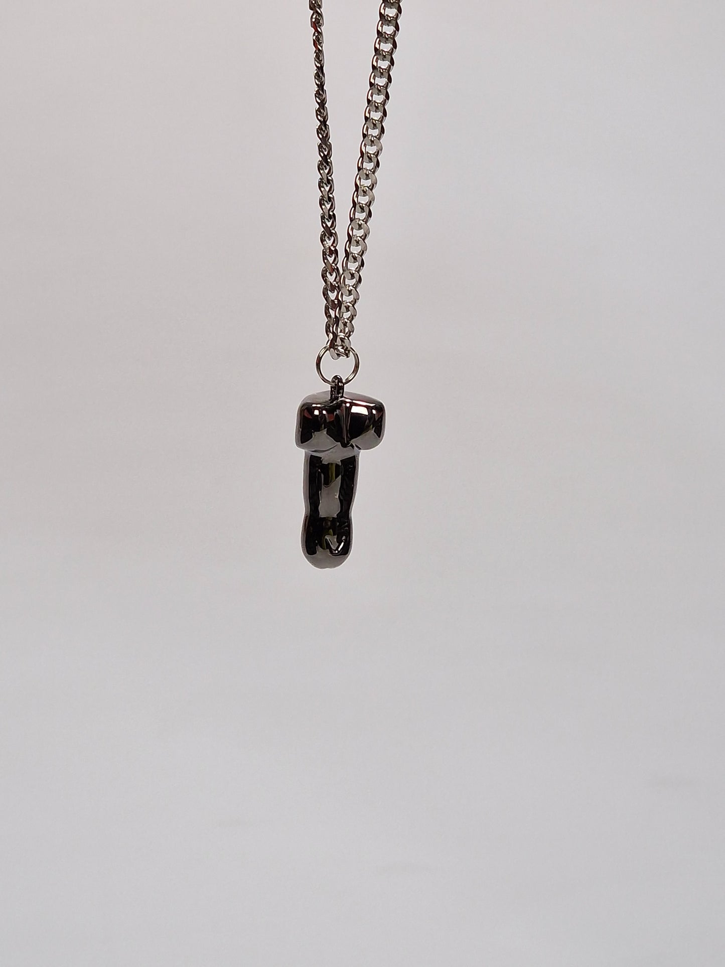 Ett vackert halsband med ett penisformat hänge. Hängsmycket är en snopp eller penis i svart metall på 2,5 cm