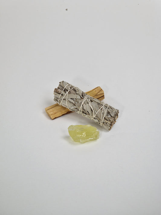Ein Paket mit einem rohen Citrinkristall, einem großen Bündel Salbei und einem Stück Palo Santo, dem heiligen Holz