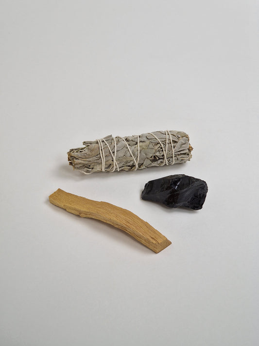 Paket aus schwarzem Onyx oder schwarzem Onyxkristall mit einem großen Bündel weißem Salbei und einem Stück Palo Santo