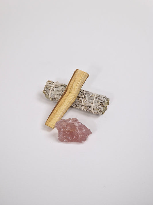 Rosenquarz, Rosenquarzkristall mit weißem Salbei, Räucherstäbchen und einem Stück Palo Santo, heiligem Holz