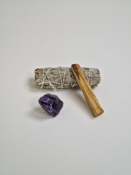 Roher Amethystkristall mit großem Bündel weißem Salbei, einem Stück Palo Santo oder heiligem Holz