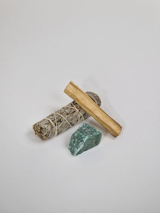 Grön Aventurine kristall med vit salvia, smudge stick och Palo Santo, heligt trä